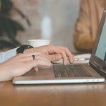 Laptop und tippende Hände